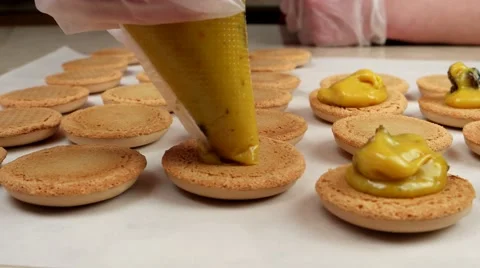 Macarons halves coated with yellow cream Stock Footage 62426264