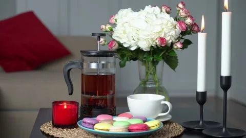 Macarons, hot black tea and flowers on the table Stock Footage 168946291