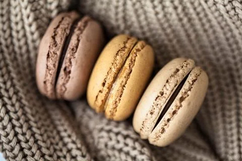 Macarons on knitted material. Background. Autumn. Sweets. Celebration. Gift.. Foto stock