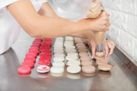 Macarons manufacturing, step by step process. Close up image of hands of female Stock Photos