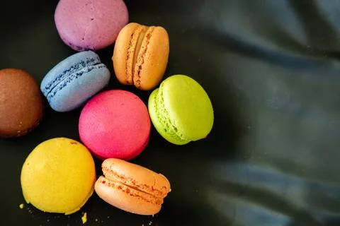 Macarons pastel colors with chocolate cream on black background, close up vie Stock Photos