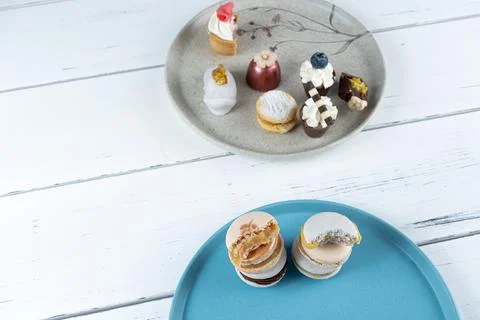 Macarons stacked alongside assorted fancy sweets top view. Stock Photos