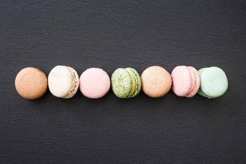 Macarons, top view flat lay, sweet macaroon on black slate Stock Photos