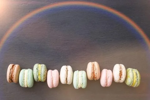 Macarons, top view flat lay, sweet macaroon on rainbow black slate Stock Photos