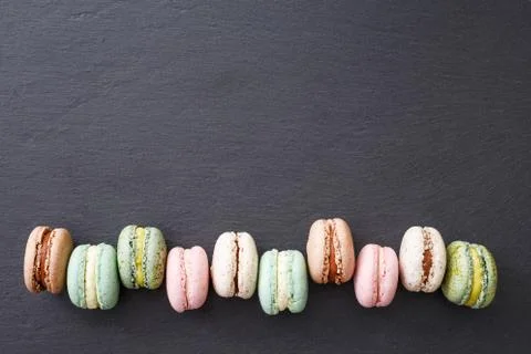 Macarons, top view flat lay, sweet macaroon on black slate Stock Photos