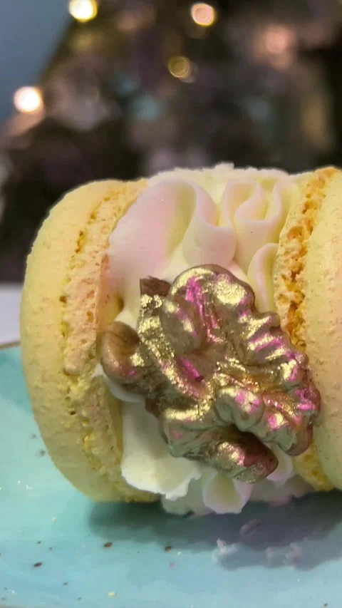 Macarons with walnuts and yellow edible gold dessert on a blue plate vertical Video stock 257265643