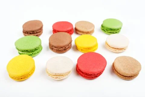 Macarons on a white background. Many colored macaroons top view. Stock Photos