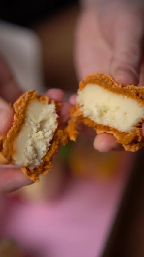 Macaroon in a crack. Hands break in half orange french dessert macaroon. Stock Footage 294720505