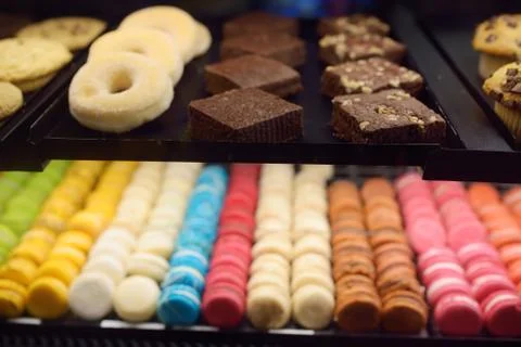 Macaroon, donuts, biscuits, muffins in the window of a cafe or store Stock Photos