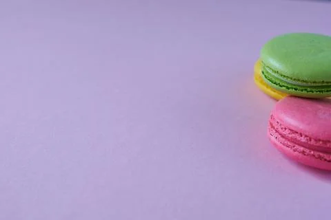 Macaroon halves on a lilac background. Copy space. Stock Photos