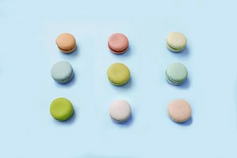 Macaroon or macaron biscuits on light blue background. Stock Photos