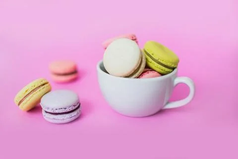 Macaroon or macaron biscuits in mug on pink background. Stock Photos