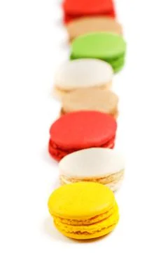 Macaroon row on a white background. Sweet pastries with food dyes. Stock Photos