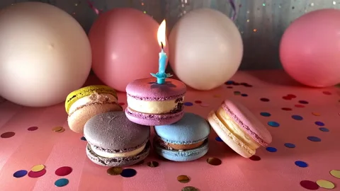 Macaroons and one candle on blue and pink background with decorations 動画素材 237471580