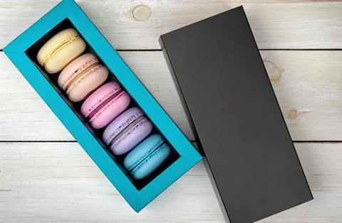 Macaroons in box next to lid Stock Photos