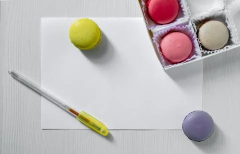 Macaroons cookies on a table next to a postcard and pen. view from above. Stock Photos
