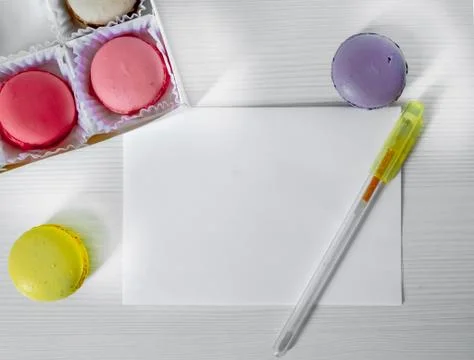 Macaroons cookies on a table next to a postcard and pen. view from above. Stock Photos