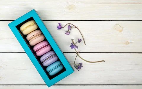 Macaroons in gift box next to violet 스톡 사진