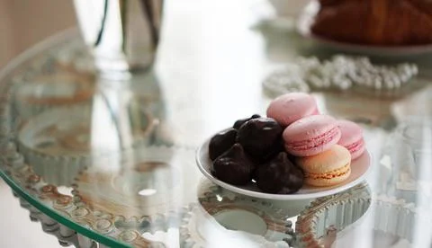 Macaroons on a glass table. Sweets for breakfast. Sunny photo Stock Photos