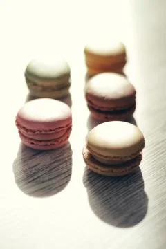 Macaroons illuminated by sun rays casting their shadow Stock Photos