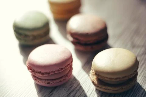 Macaroons illuminated by sun rays casting their shadow Stock Photos