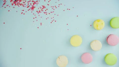 Macaroons or macaron with small red hearts on pastel blue surface. Close up. Fotos Stock
