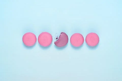 Macaroons in row on blue table top view Stock Photos
