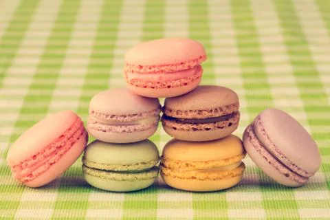 Macaroons stacked on checkered tablecloth Stock Photos