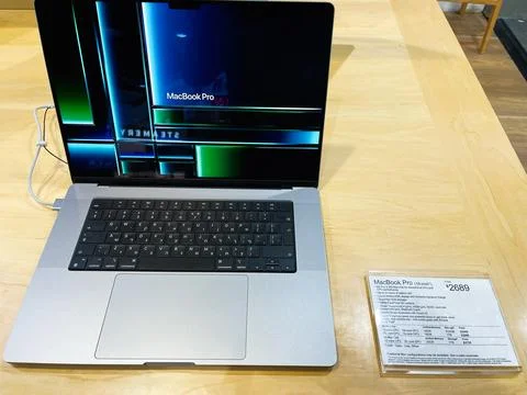 MacBook Pro on display at store with price tag beside sleek laptop Stock Photos