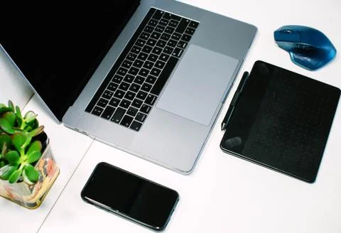Macbook pro, iphone, mousse and drawing tablet on white table Stock Photos