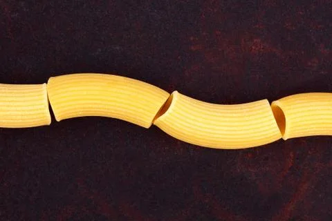 Maccheroni raw pasta on rusty background Stock Photos