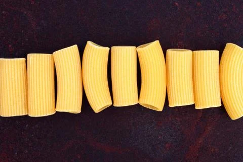 Maccheroni raw pasta on rusty background Stock Photos