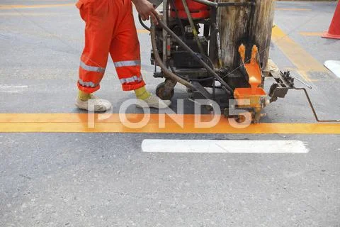 Machine and worker at road construction Stock Photos