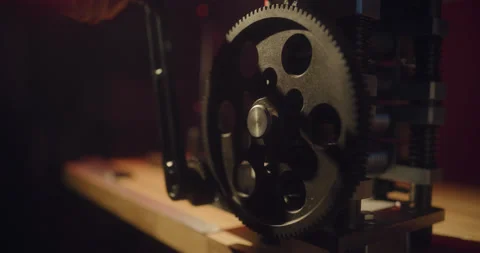 Machine with a big cogwheel on a dark red background Stock Footage 130967911