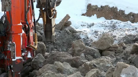 Machine boring terrestrial rocks in winter, pile of ground beside it Stock Footage 8653975