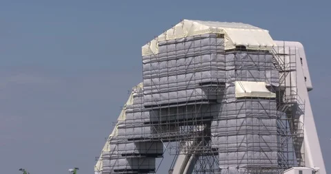 Machine building on the top of the arch covered in scaffolding wrap Video stock 111937178