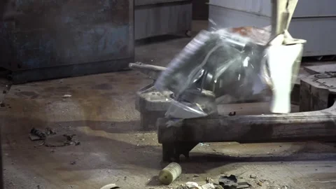 Machine claw crushing a scrapped white appliance flat against a steel press bed Stock Footage 340565768
