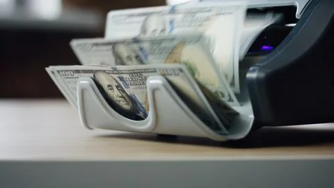 Machine counting dollar bills close up. Equipment for paper money calculation. Stock Photos