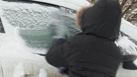 Machine, covered with snow. A man brushing snow from the car. Stock Footage 146111402