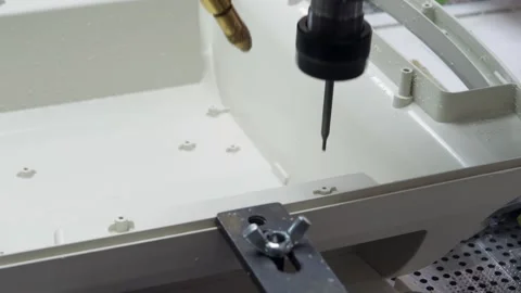 The machine drills holes in a plastic part. Stock Footage 130650299