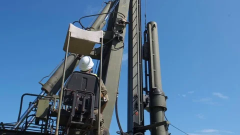The machine drives a pile wooden structure into the ground. Construction of the  Stock Footage 123871305