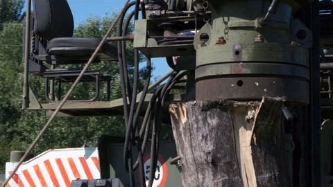 The machine drives a pile wooden structure into the ground. Construction of the  Stock Footage 123871395