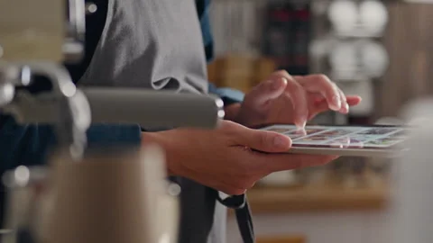 Machine, an employee looks into a modern touch tablet in a coffee bakery. Ge Stock Footage 247205433