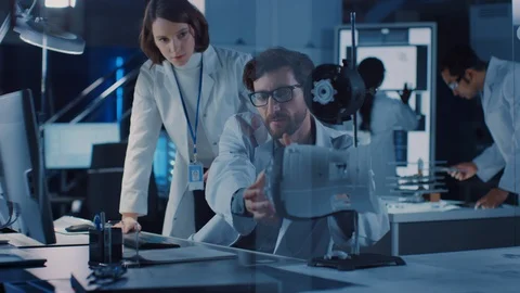 Machine Engine Development Engineer Working on Computer at His Desk, Talks Stock Footage 104853804