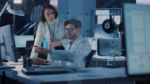 Machine Engine Development Engineer Working on Computer at His Desk, Talks Stock Footage 104855064