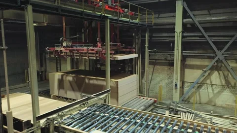 A machine is folding finished chipboard plates at the factory Stock Footage 169909448