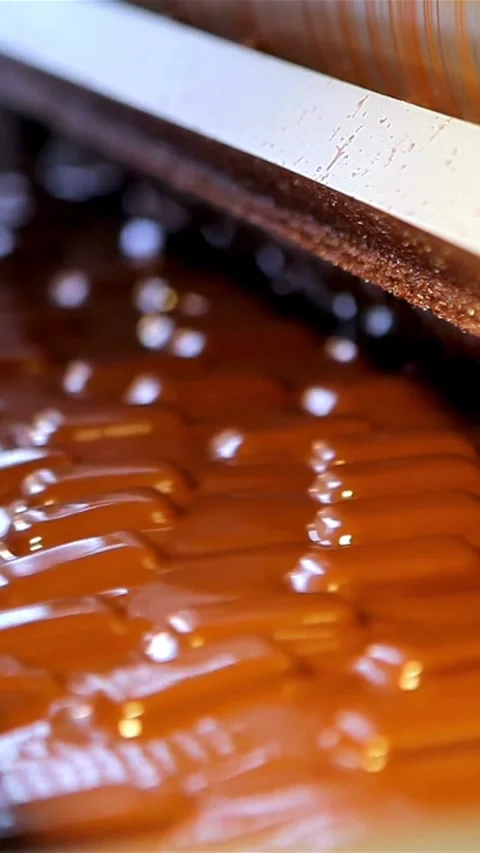 Machine forming liquid chocolate caramel bars on line Stock Footage 334169180