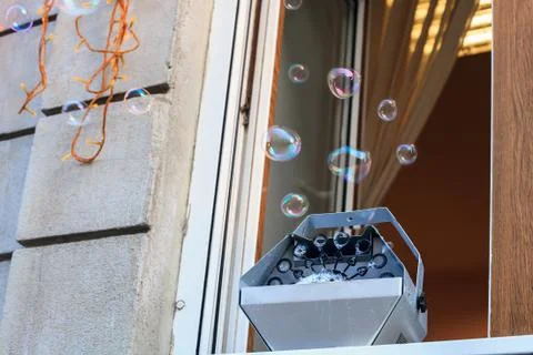 Machine generator for soap bubbles stands on window Stock Photos