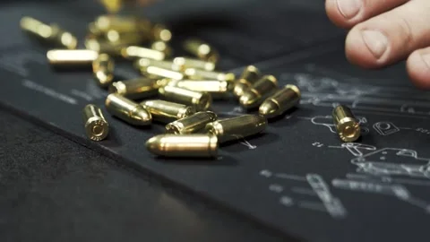 Machine gun ammo spills out onto the table in slow motion Stock Footage 254028699