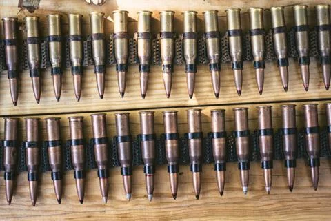 Machine gun ammo on a wooden table, bullet belt, bandoleer, chain of ammo on  Stock Photos